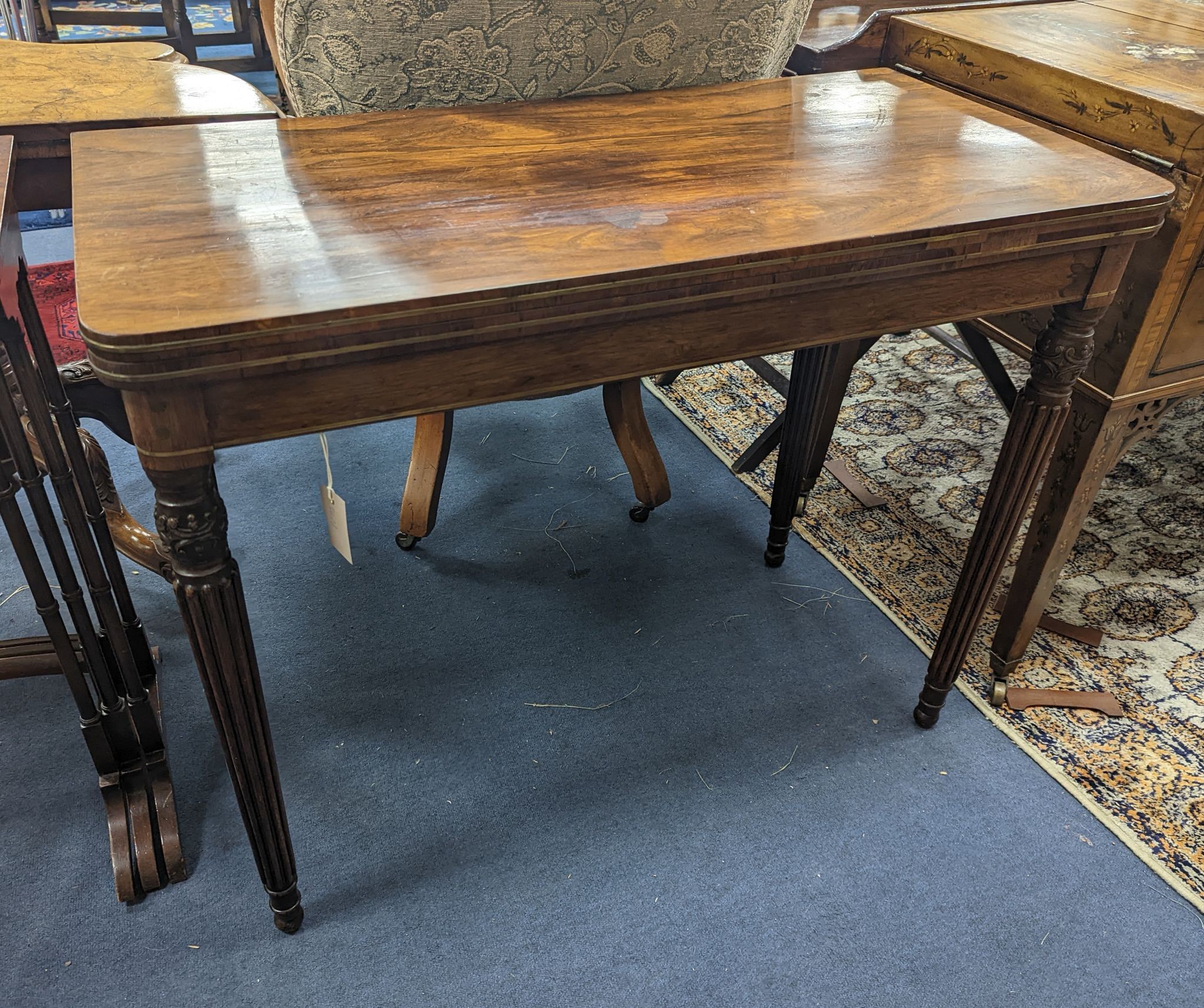 A Regency rosewood brass mounted rectangular folding card table with fluted legs, in the manner of Gillows, width 95cm, depth 47cm, height 75cm